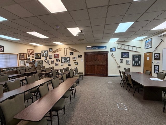 Meeting room with tables, walls covered in historical rescue photos and equipment