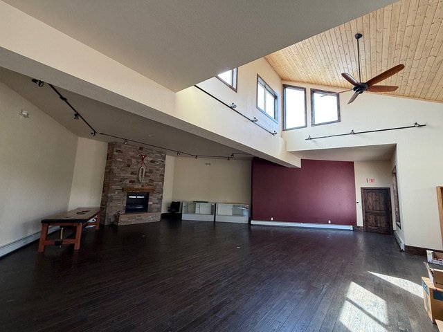 Another view of the gallery with a red accent wall and track lighting